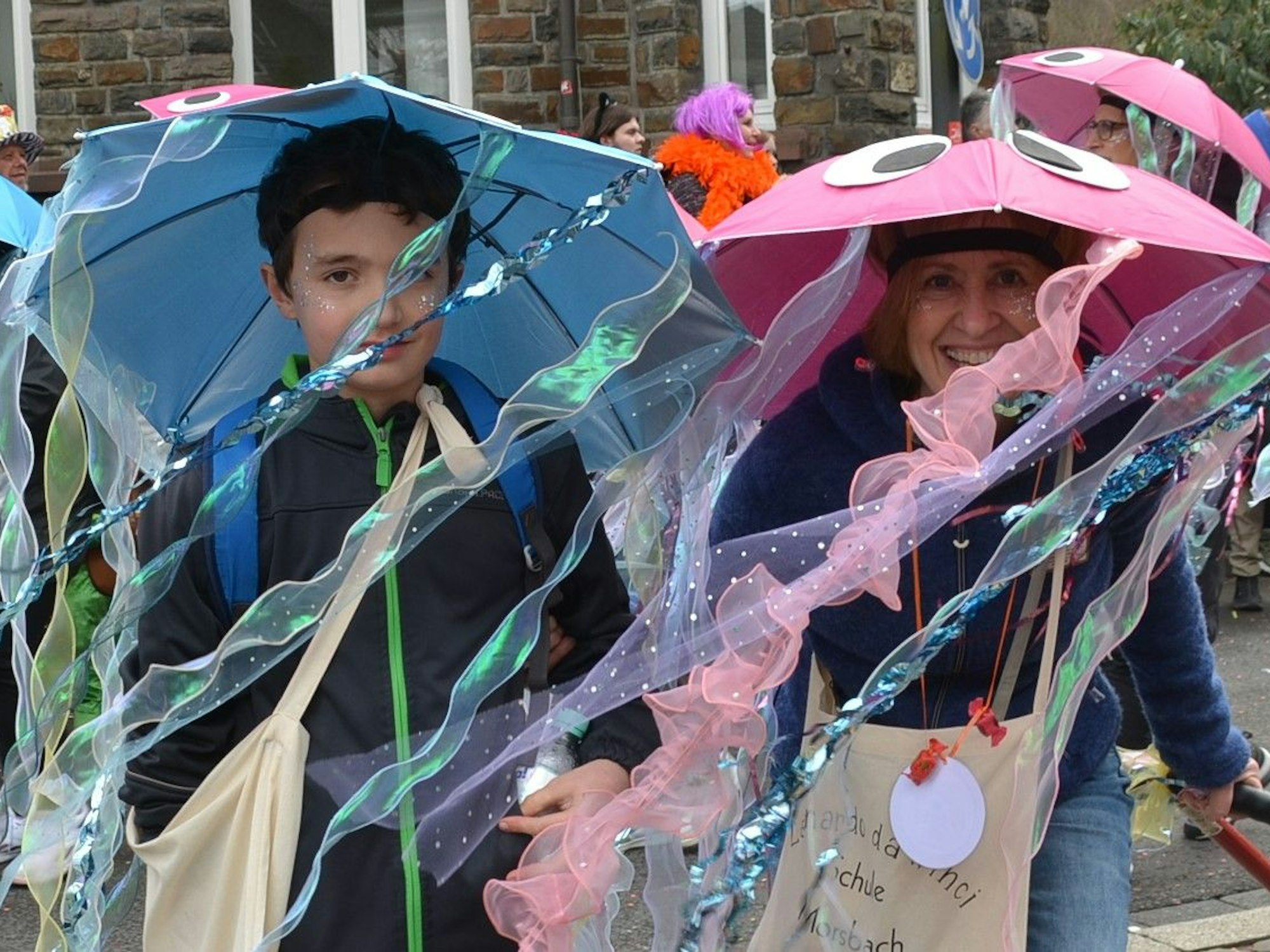 Schüler gehen als Quallen verkleidet, mit Regenschirmen auf dem Kopf, als Gruppe im Mosbacher Rosenmontagszug mit.