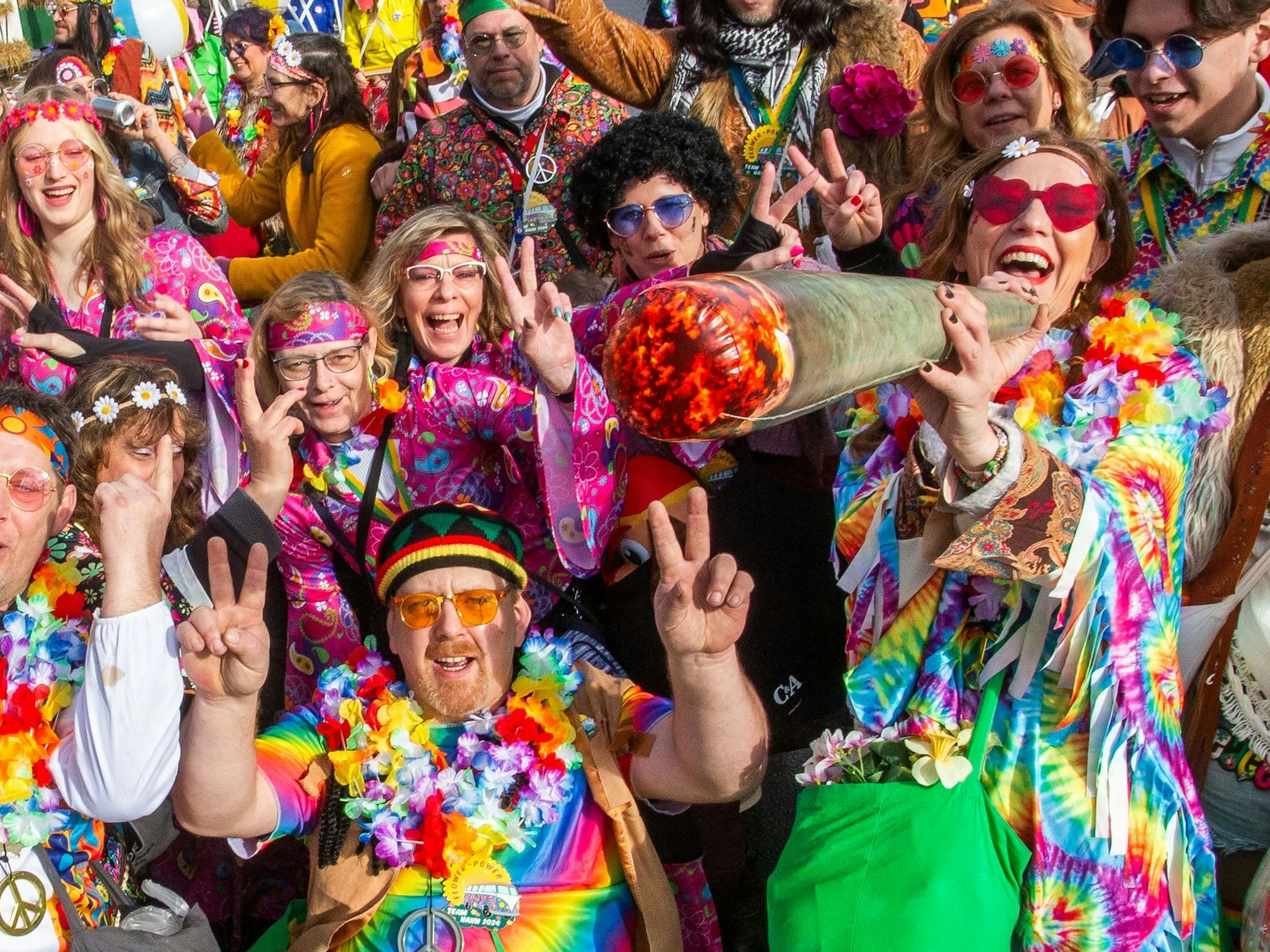Eine Gruppe bei einem Karnevalsumzug ist als Hippies verkleidet.