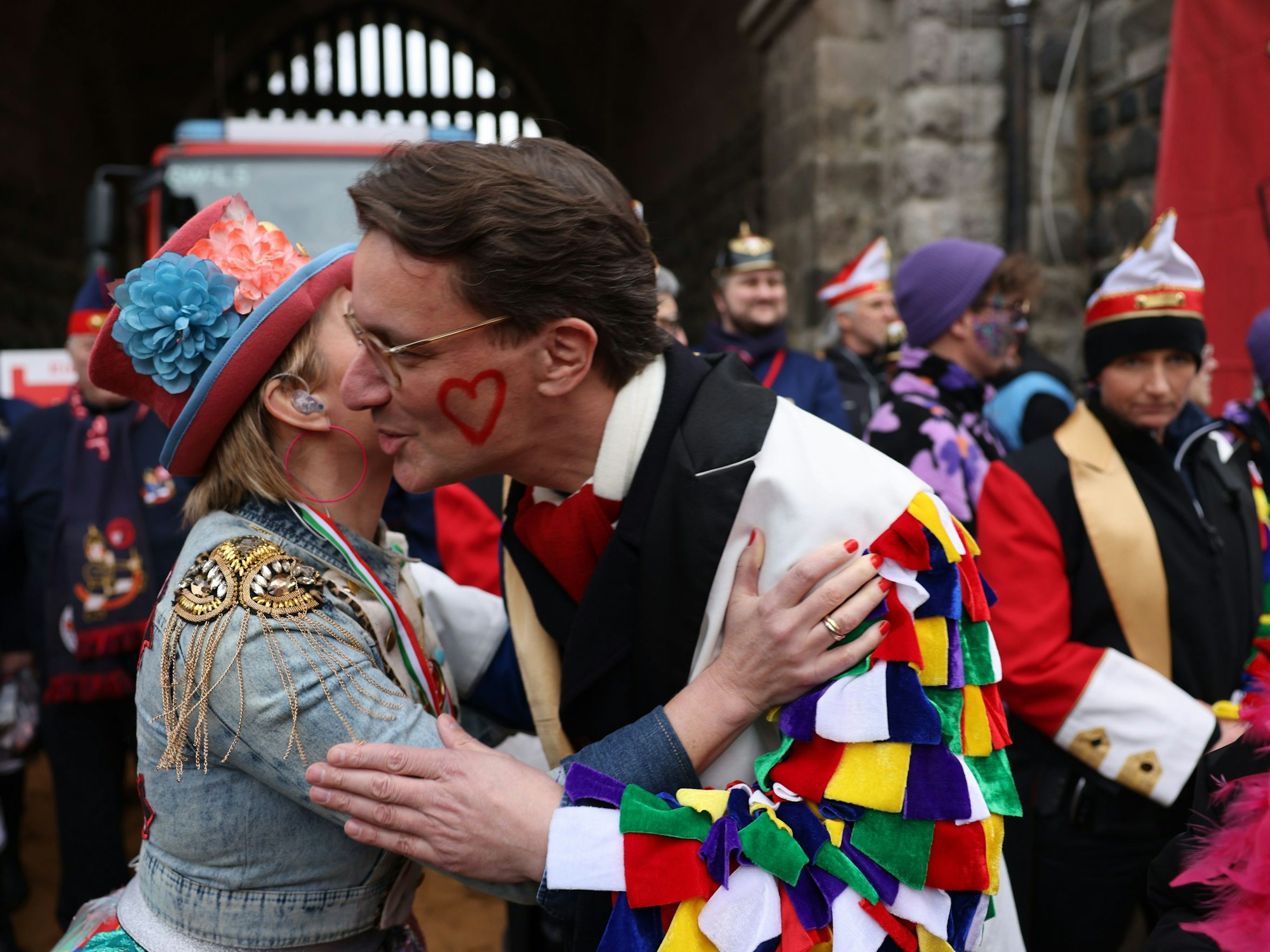 Eine Frau küsst NRW-Ministerpräsident Henrik Wüst auf die Wange.