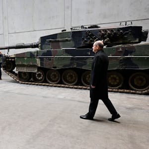 Olaf Scholz (r.) steht vor einem Leopard-Panzer. Der Bundeskanzler ist zu einem symbolischen Spatenstich und der Einweihung des neuen Rheinmetall-Werks ins niedersächsische Unterlüß gekommen.