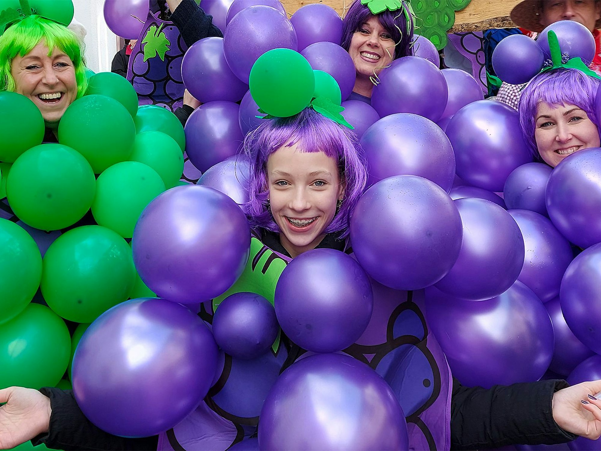 „Der Himmel voller Trauben“ diese Gruppe ging als Winzer, Winzerinnen und Reben für Rotwein (violette Luftballons) und Weißwein (grüne Luftballons).