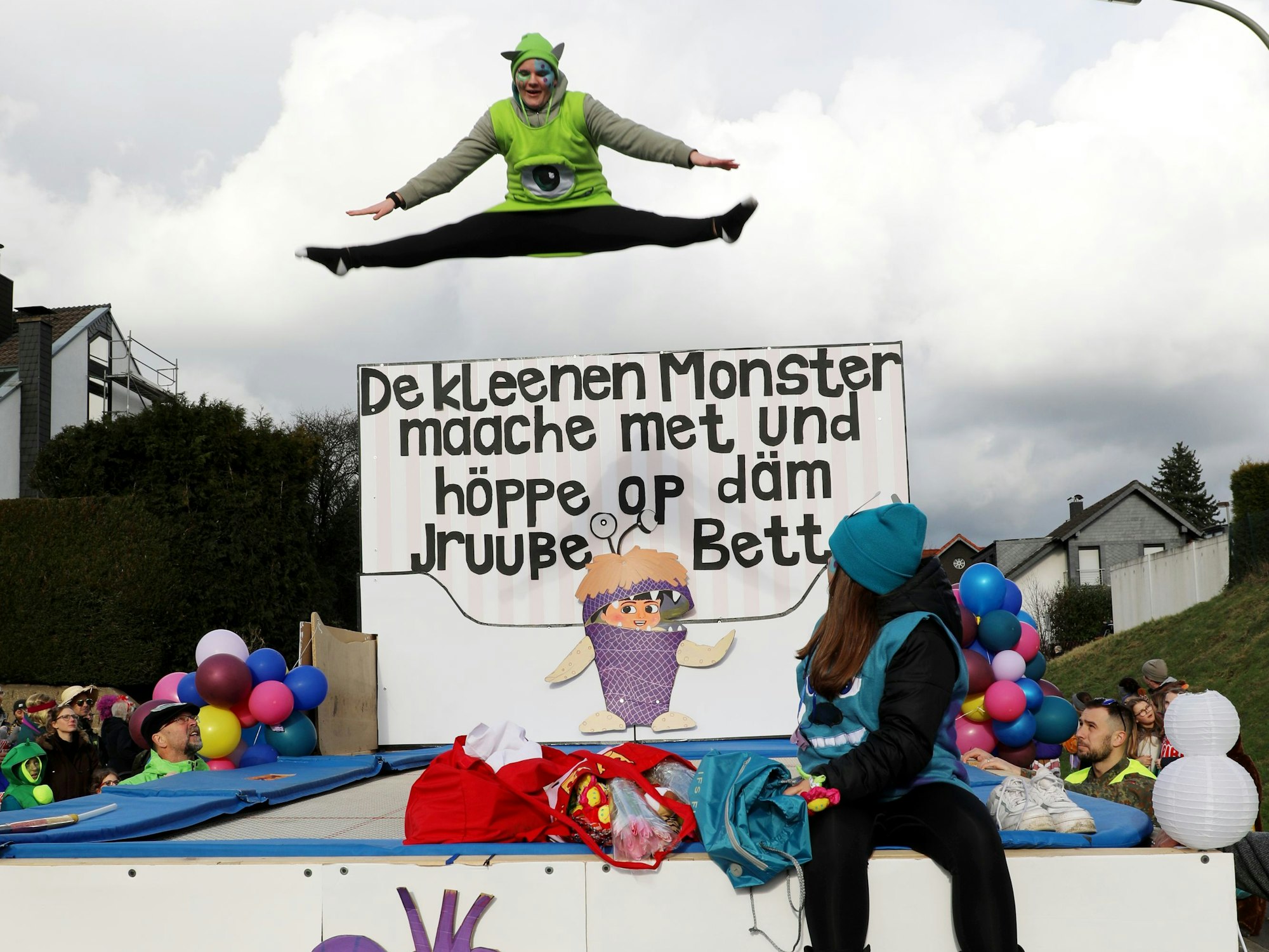 Eine Trampolinspringerin des TV Blecher springen auf einem Trampolin im Karnevalszug.