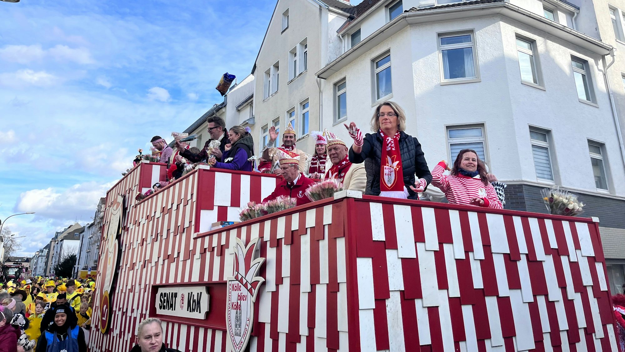 Die Karnevalsgesellschaft „Kölle bliev Kölle“ fährt mit dem Wagen in traditionellem Rot-Weiß.