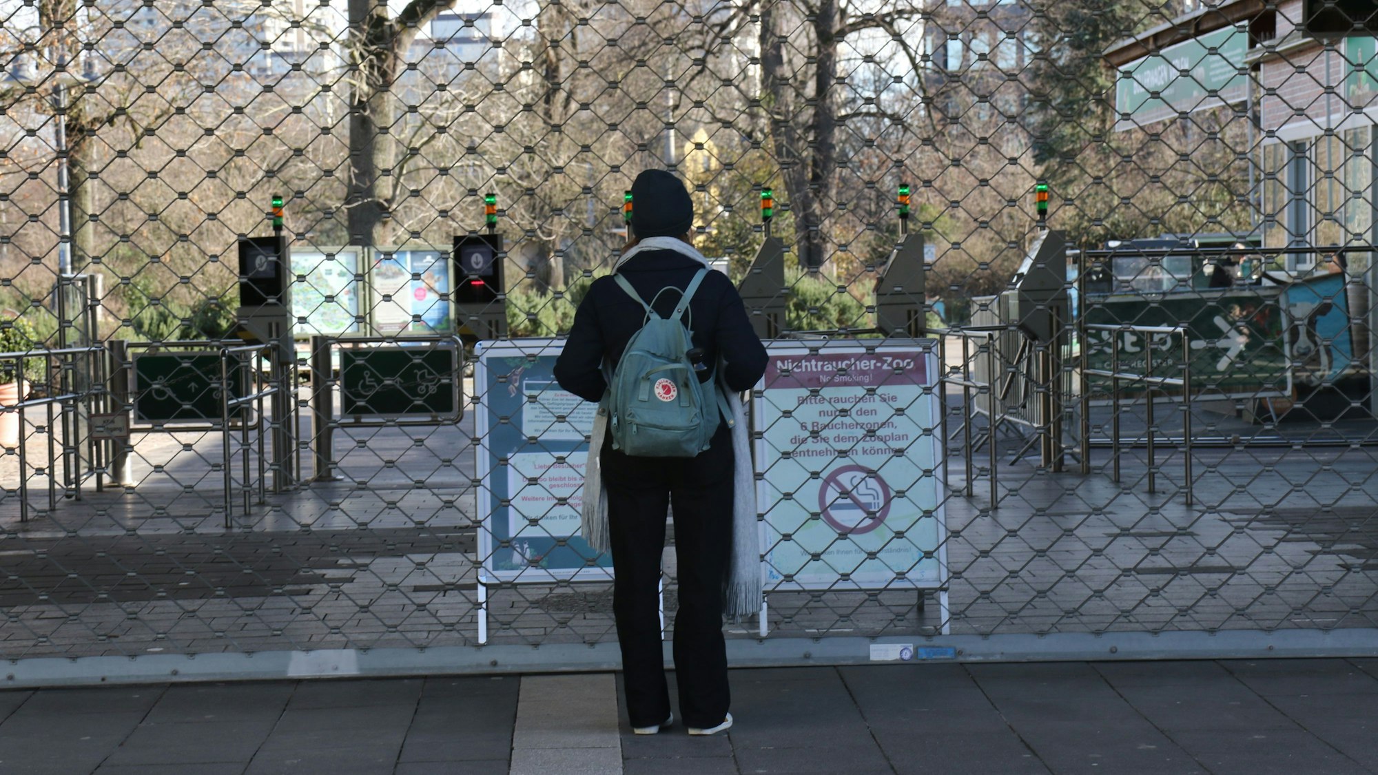 Ein Hinweisschild vor dem vergitterten Haupteingang des Kölner Zoos weist auf die Schließung hin.