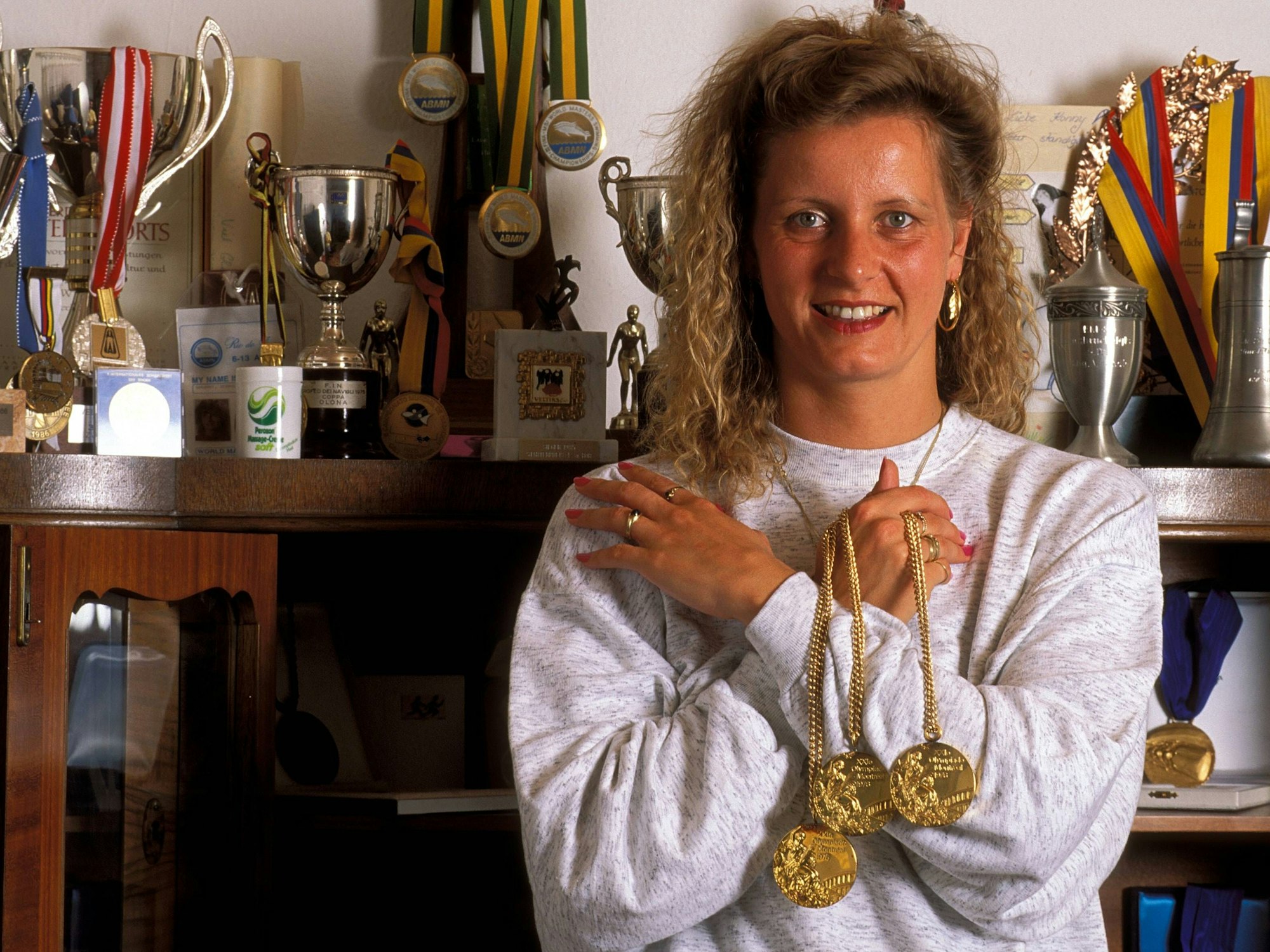 Kornelia Ender-Grummt steht 1992 mit ihrer Medaillensammlung vor ihrer Pokal-Vitrine.
