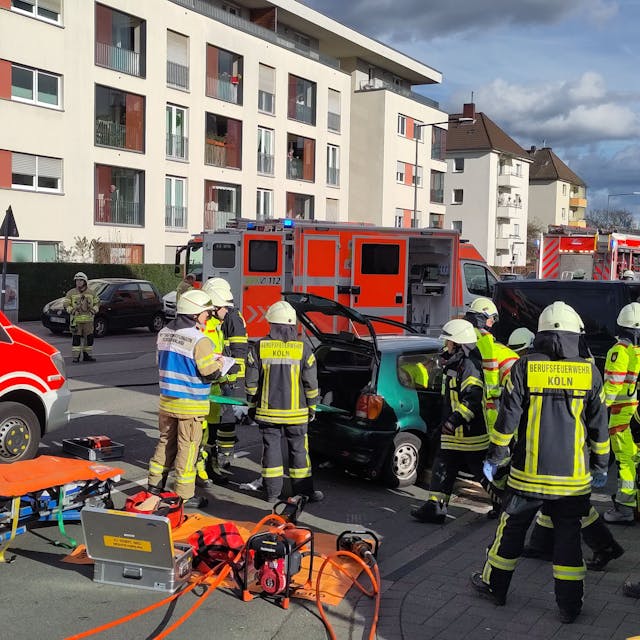Feuerwehr und Rettungsdienst stehen auf der Straße nach einem Auffahrunfall auf der Friedrich-Karl-Str. in Niehl.