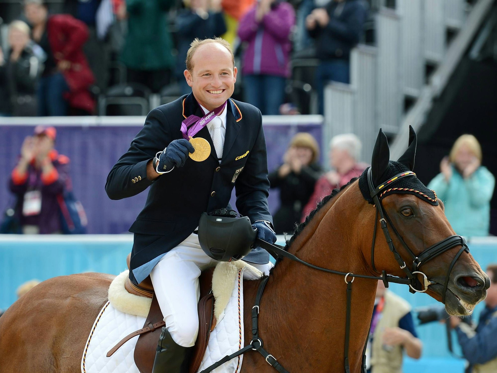 Michael Jung freut sich auf seinem Pferd über den ersten Platz bei Olympia.