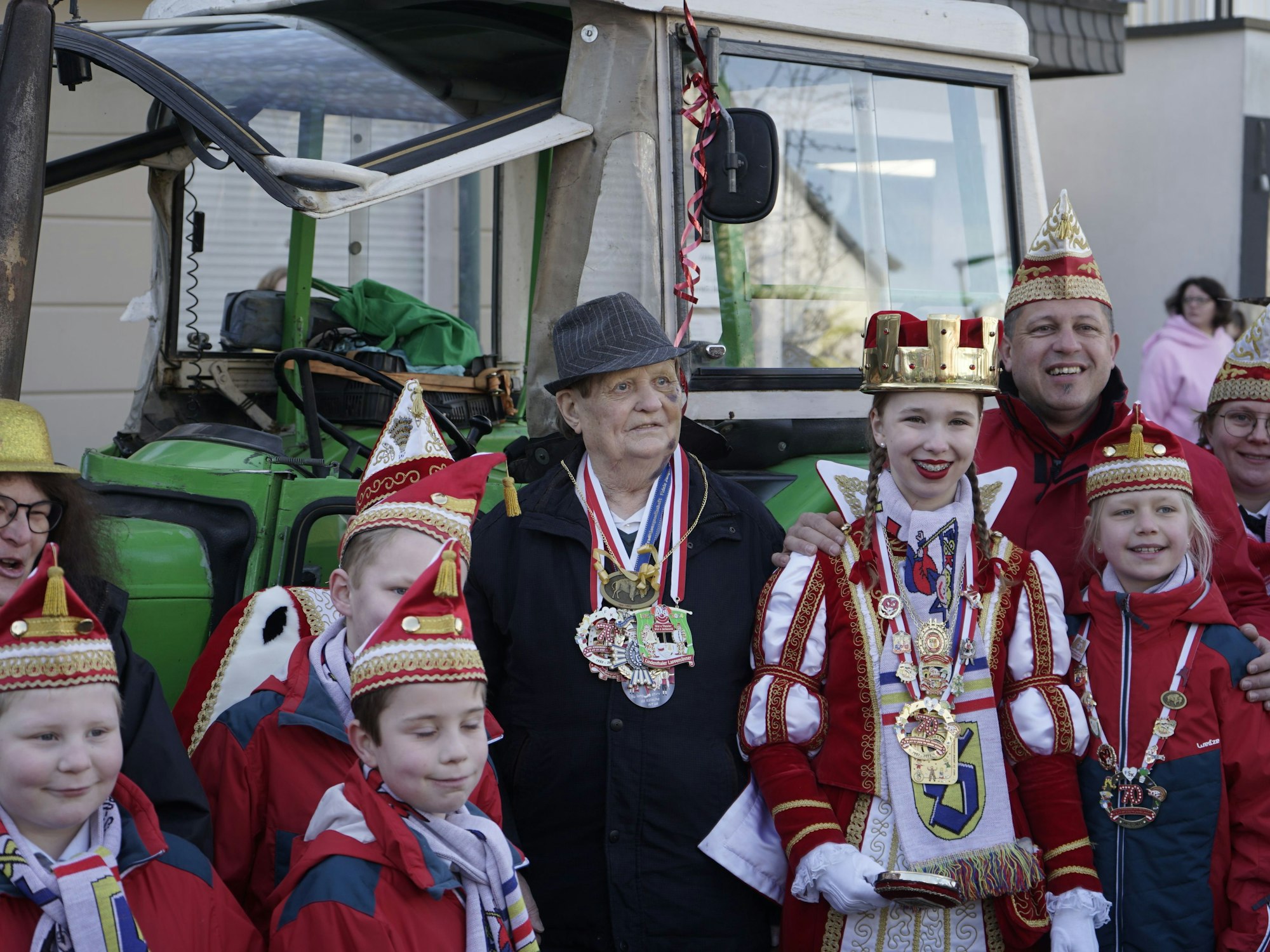 Alfred Knaak mit dem Kinderdreigestirn vor seinem Traktor.