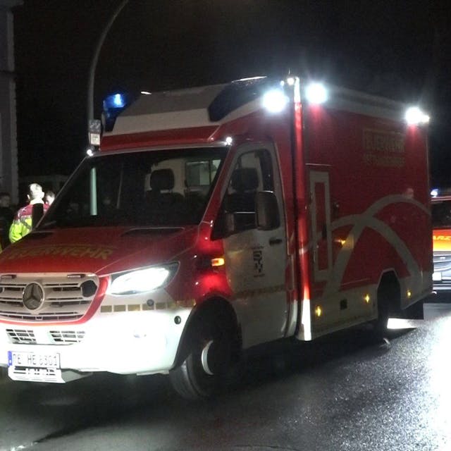 Rettungswagen stehen auf einer Straße.