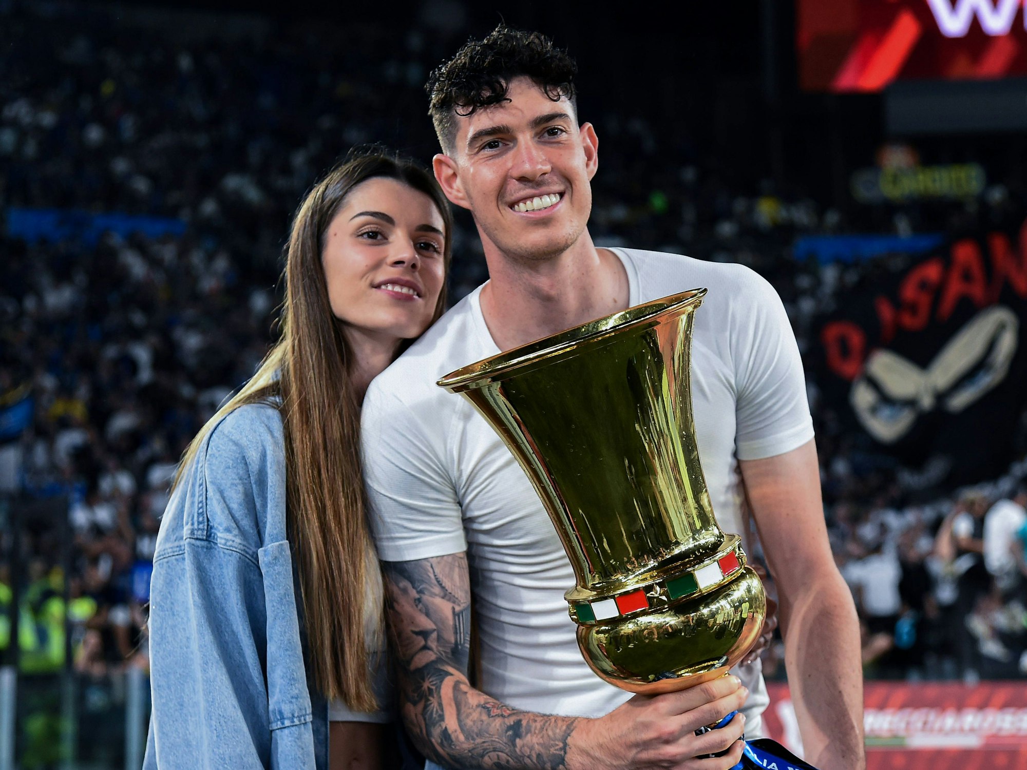 Alessandro Bastoni mit dem italienischen Pokal in der Hand neben seiner Freundin Camilla Bresciani