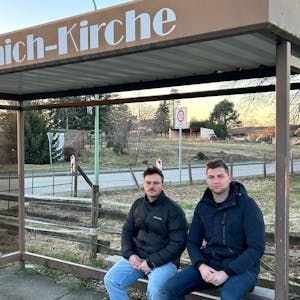 Lennart Bongart und Calvin Köcher (v.l.) sitzen im Haltestellenhäuschen von Morschenich. Sie planen, in ihre altes Dorf zurückzukehren, wenn die Bedingungen stimmen.