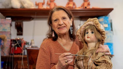 Joyce Merlet in ihrer Puppenklinik mit einer historischen Puppe