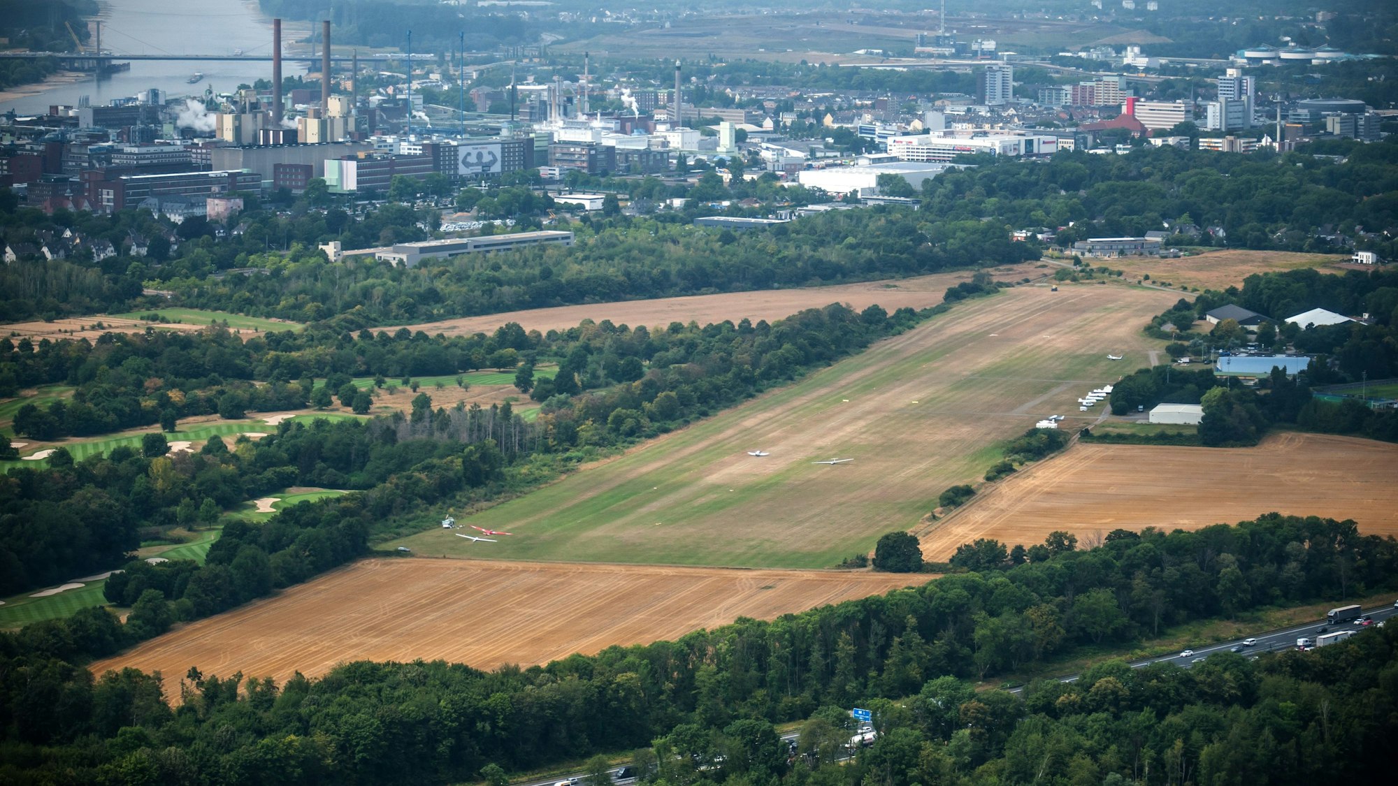 Der Flugplatz Kurtekotten aus der Vogelperspektive. Im Hintergrund die Stadt Leverkusen mitsamt Bayerwerk.
