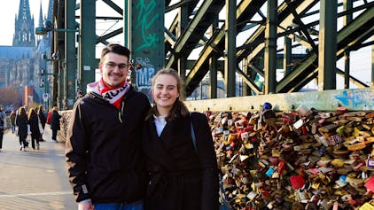 Marla Carus (26) und Sven Turi (26) bringen ihr Liebesschloss an der Kölner Hohenzollernbrücke an.