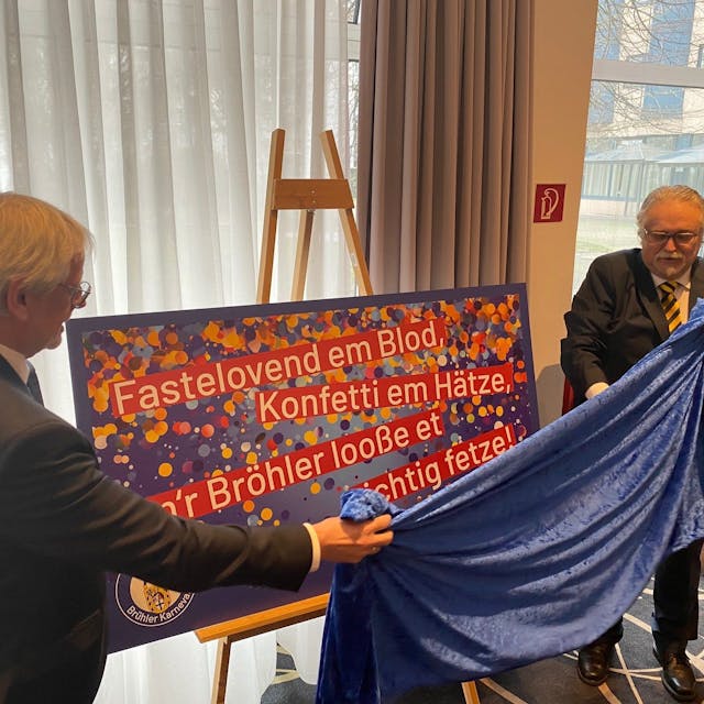 Zu sehen sind Festausschuss-Präsident Peter Lautenschläger und Bürgermeister Dieter Freytag beim Enthüllen eines Plakats.