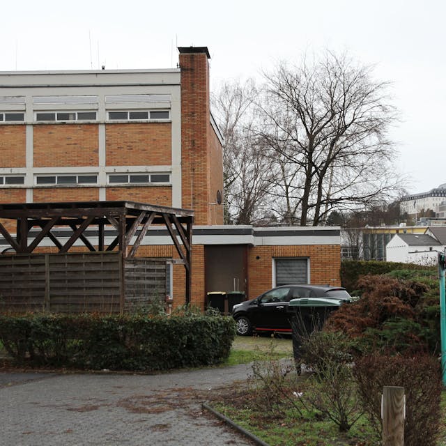 Ein beige verklinkertes Schulgebäude, im Hintergrund die Abtei auf dem Michaelsberg&nbsp;