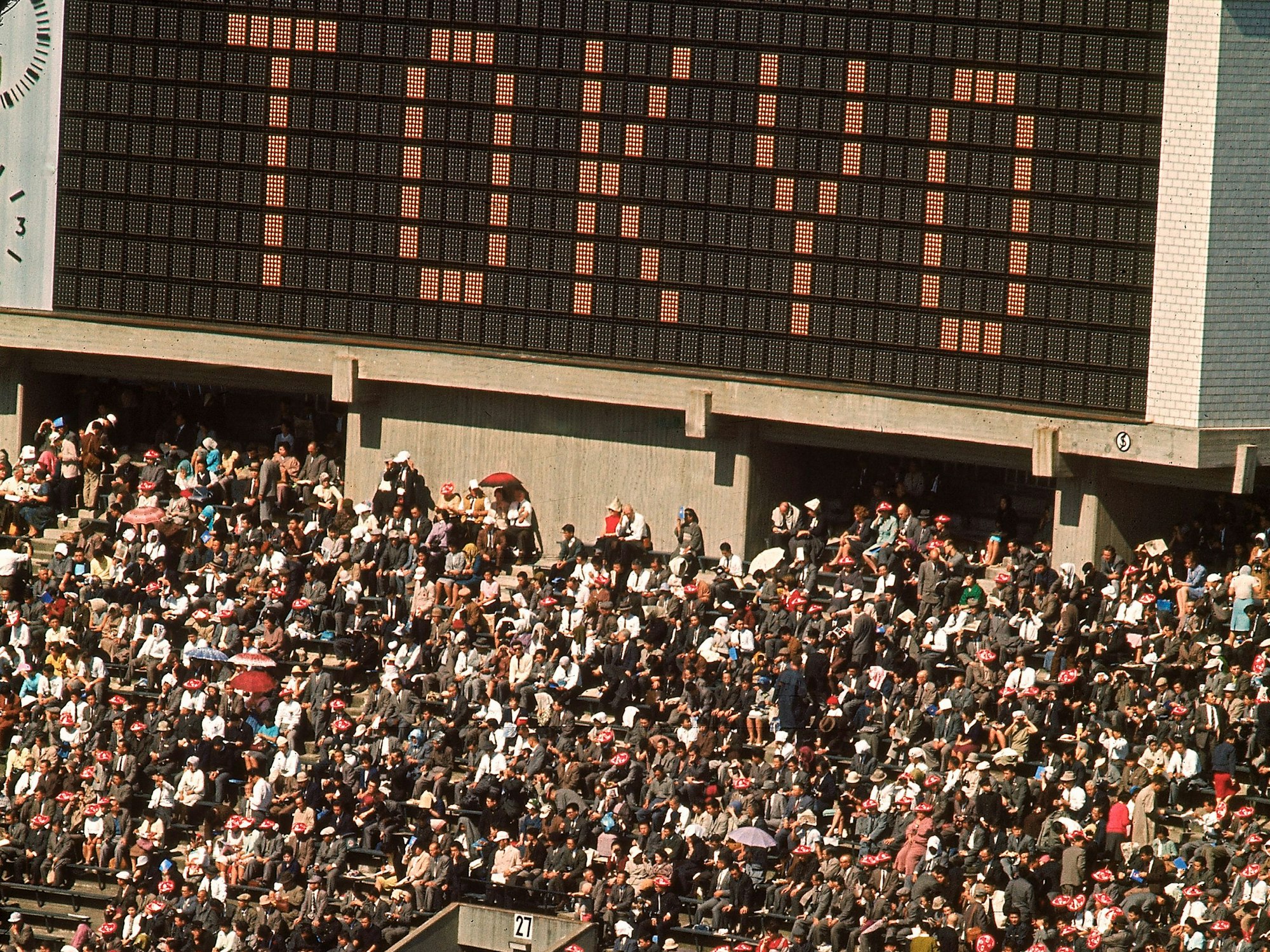Ein Blick in das Nationalstadion. Auf der Anzeige steht Tokyo und die Tribüne darunter ist mit Fans gefüllt.