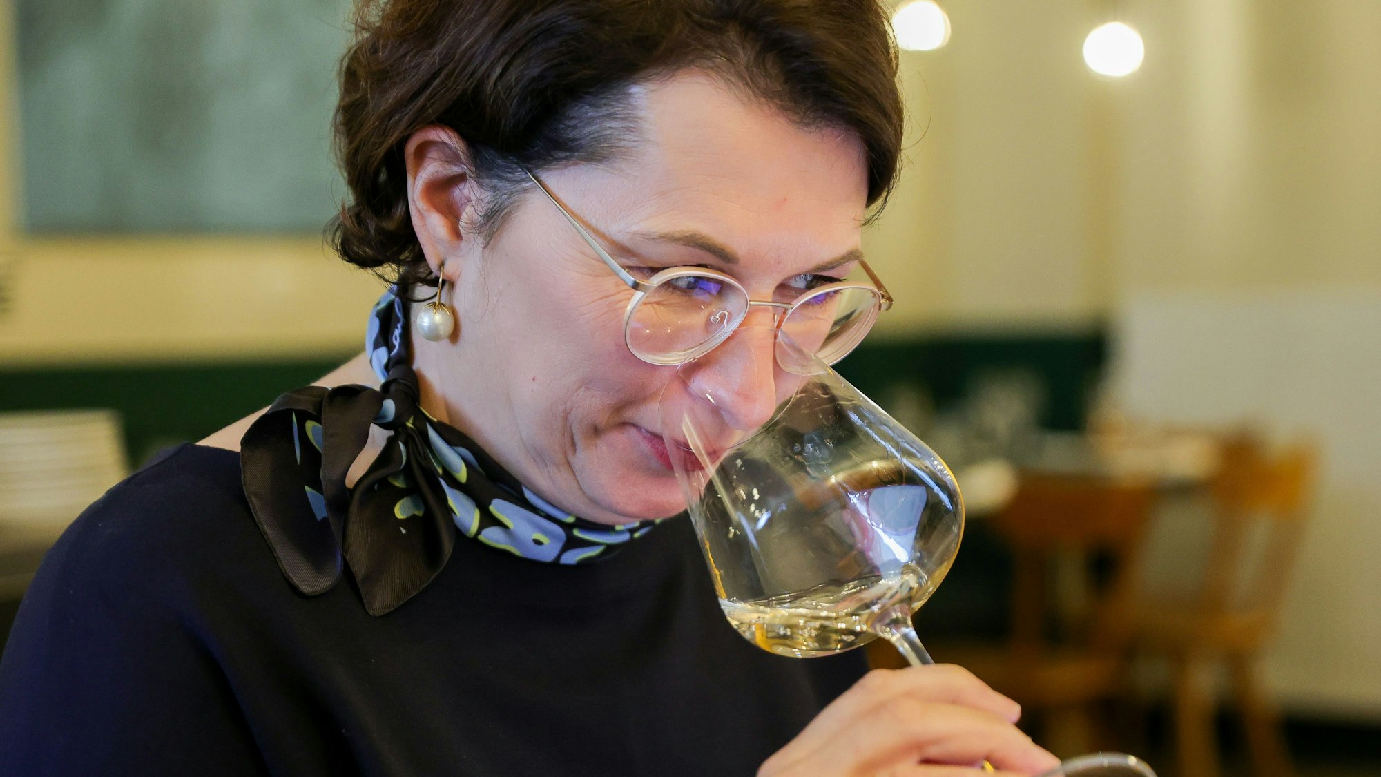 Romana Echensperger riecht an einem Glas mit Weißwein