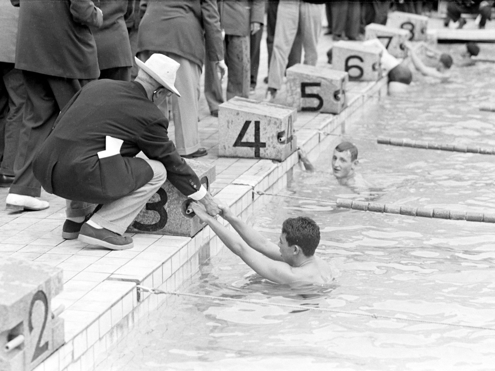 Schwimmer im Wasser an den Startblöcken im Anschluss an ihren Wettkampf.