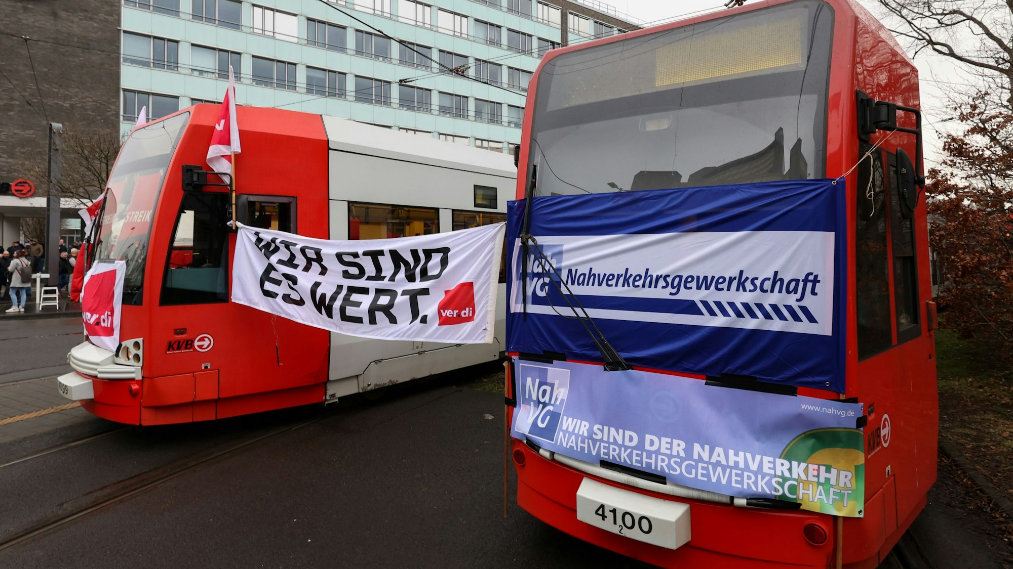 Zwischen zwei Bahnen der Kölner Verkehrs-Betriebe (KVB) hängt ein Plakat der Gewerkschaft Verdi, auf dem „Wir sind es wert“ geschrieben steht. Die Beschäftigten im öffentlichen Nahverkehr in Nordrhein-Westfalen streiken für bessere Arbeitsbedingungen.