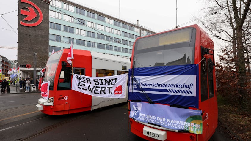 Zwischen zwei Bahnen der Kölner Verkehrs-Betriebe (KVB) hängt ein Plakat der Gewerkschaft Verdi, auf dem „Wir sind es wert“ geschrieben steht. Die Beschäftigten im öffentlichen Nahverkehr in Nordrhein-Westfalen streiken für bessere Arbeitsbedingungen.