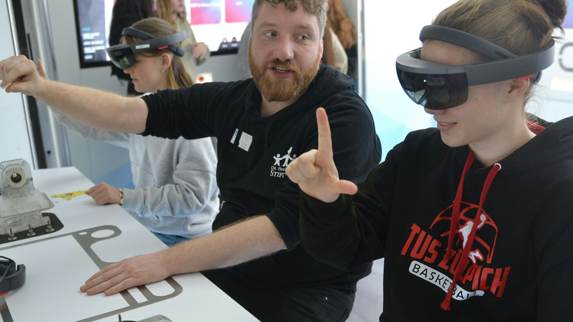 Eine Schülerin des Zülpicher Franken-Gymnasiums trägt eine VR-Brille. Mit ihren Händen bewegt sie virtuelle Gegenstände, die ohne Brille nicht sichtbar sind.