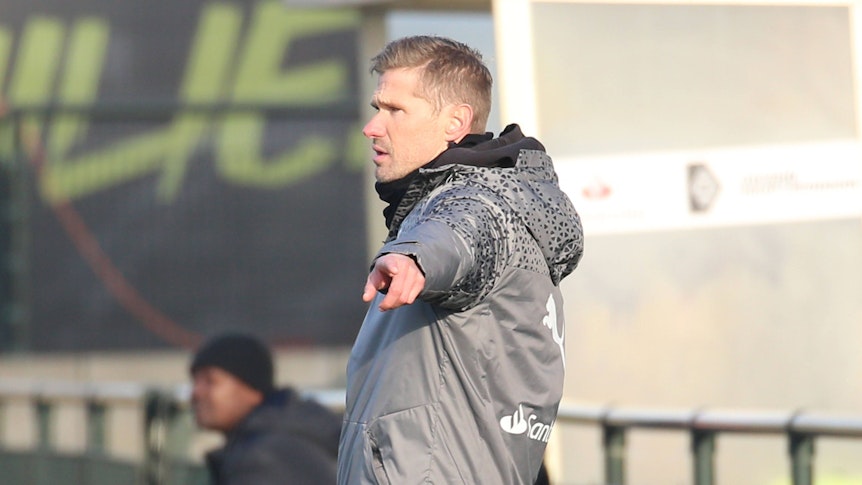 Trainer der U19 von Borussia Mönchengladbach zeigt während eines Spiels etwas an.