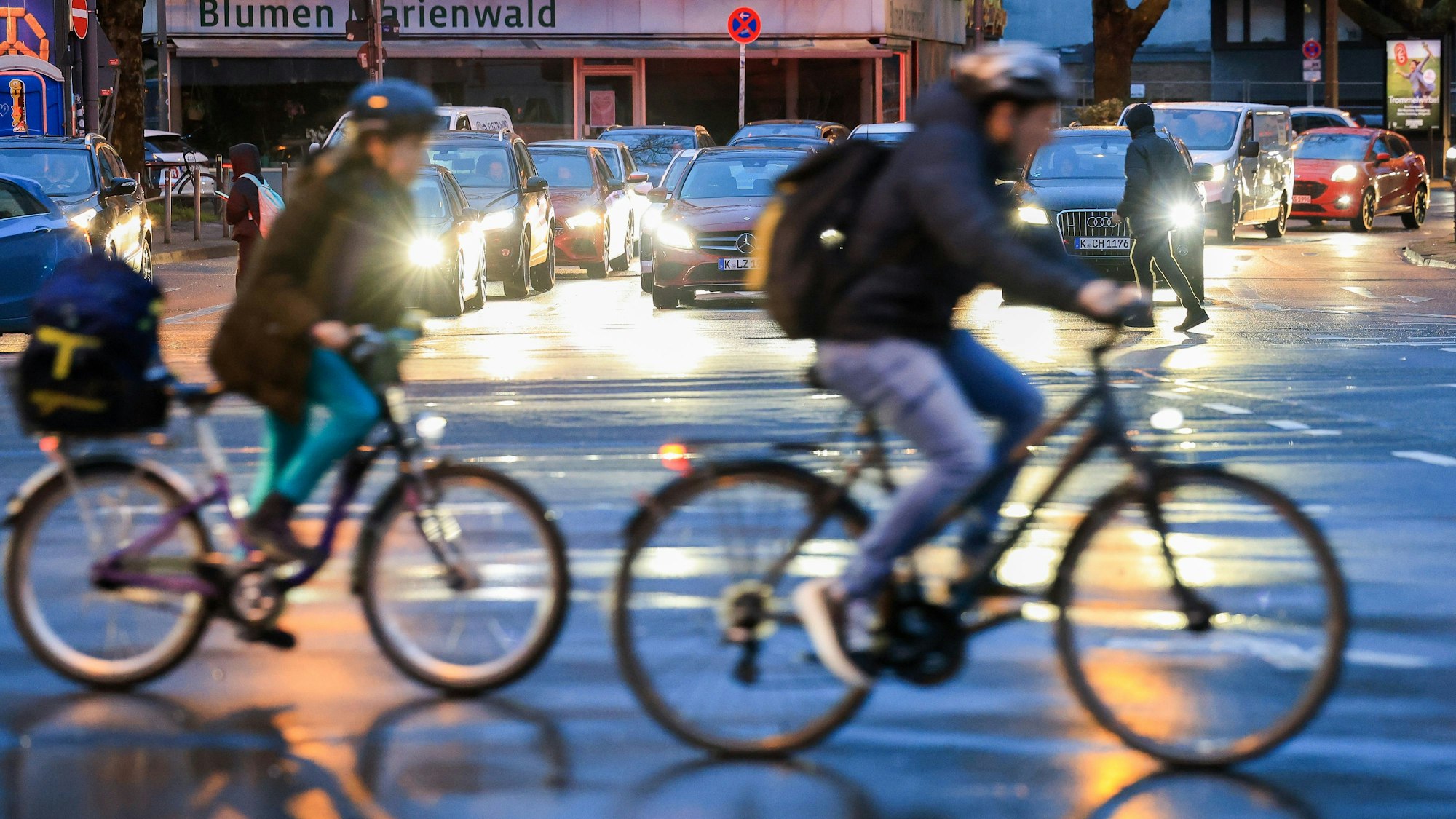 Zwei Fahrradfahrer überqueren eine Kreuzung.