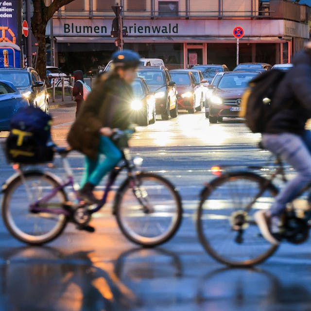 Zwei Fahrradfahrer überqueren eine Kreuzung.