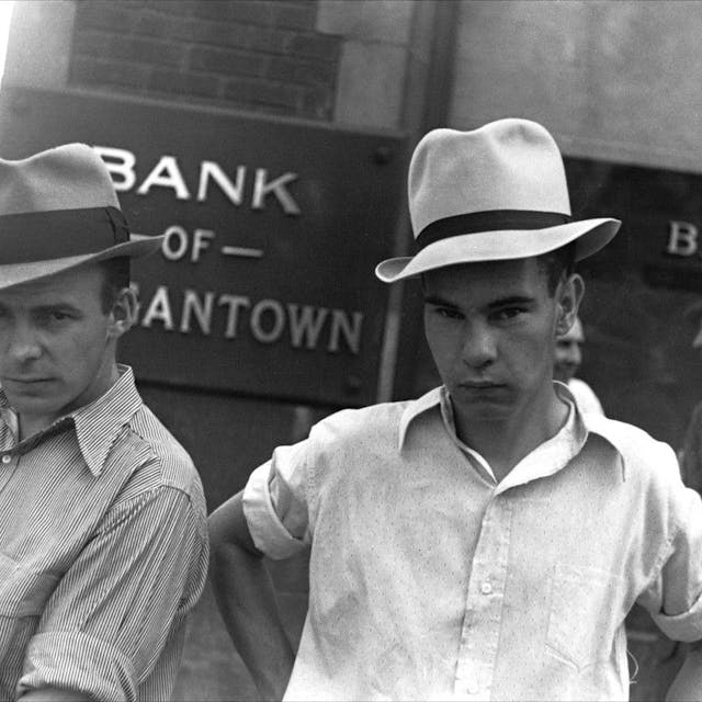 Die Schwarz-Weiß-Aufnahme „Main Street, Morgantown, West Virginia, 1935“ von Walker Evans zeigt zwei Männer, die Hüte tragen und vor einem Bankgebäude stehen.
