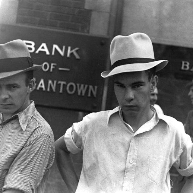 Die Schwarz-Weiß-Aufnahme „Main Street, Morgantown, West Virginia, 1935“ von Walker Evans zeigt zwei Männer, die Hüte tragen und vor einem Bankgebäude stehen.