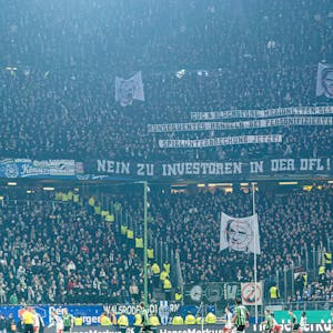 Fans von Hannover 96 zeigen ihren Geschäftsführer Martin Kind im Fadenkreuz, darüber erklären sie mit Spruchbannern die Bedeutung dieser Darstellung.