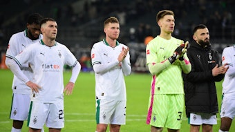 Spieler von Borussia Mönchengladbach klatschen mit enttäuschenden Gesichtern.