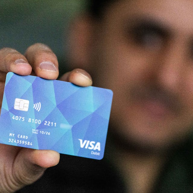 Ein Geflüchteter hält eine Debitkarte in der Hand (Symbolbild).