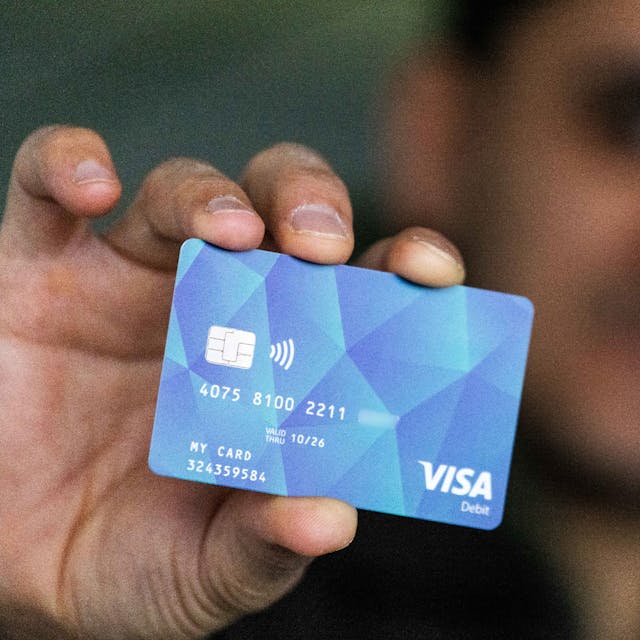 Ein Geflüchteter hält eine Debitkarte in der Hand. (Symbolbild)
