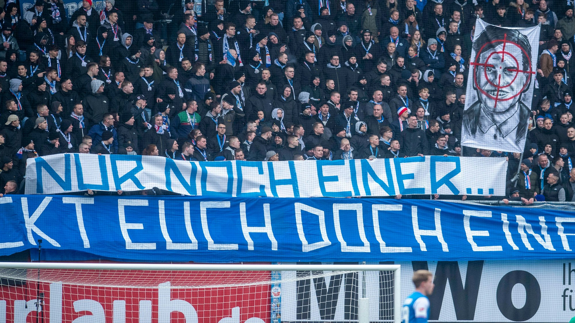 Fans des FC Hansa Rostock präsentieren ein Spruchband mit Fadenkreuz-Banner.