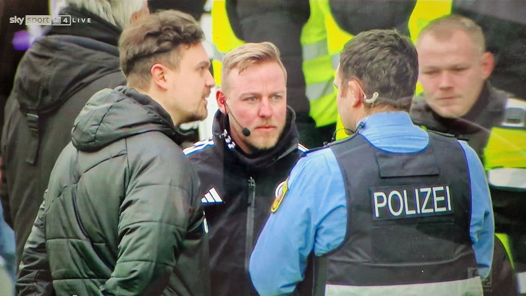 Ein Polizist spricht mit dem Vierten Offiziellen beim Spiel der 2. Bundesliga zwischen der SV Elversberg und dem VfL Osnabrück.