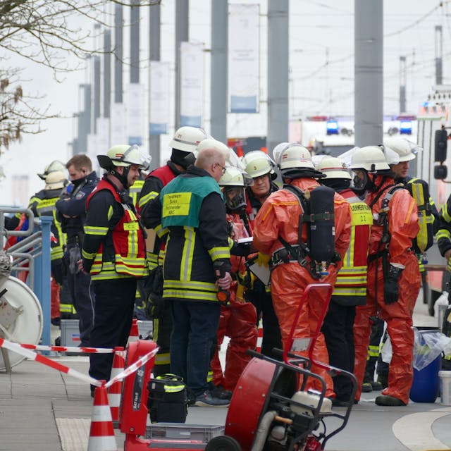Feuerwehrleute in Schutzanzügen erkunden die Lage am Brückenforum in Bonn.