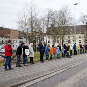 Teilnehmer einer Menschenkette zwischen Verteilerkreis und Olefbrücke in Schleiden. Einige haben Plakate dabei.