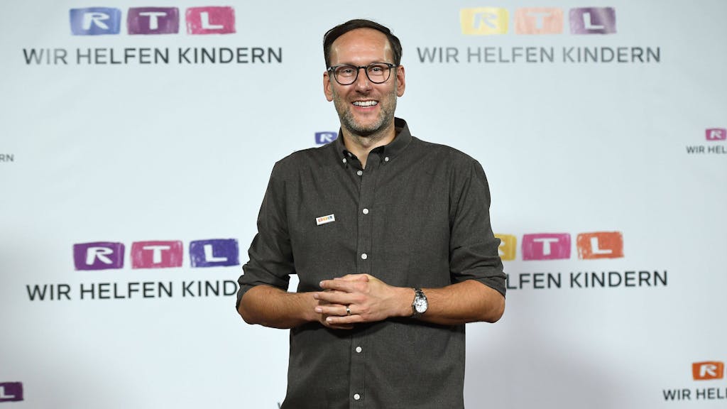 Das Foto zeigt Moderator Simon Beeck beim RTL-„Spendenmarathon“, wo er vor einer Wand voller Logos des Kölner Privatsenders steht.&nbsp;