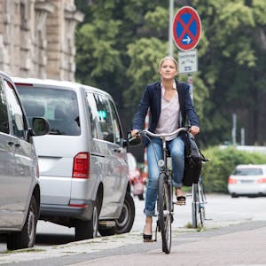 Eine Frau fährt Fahrrad in einer Stadt.
