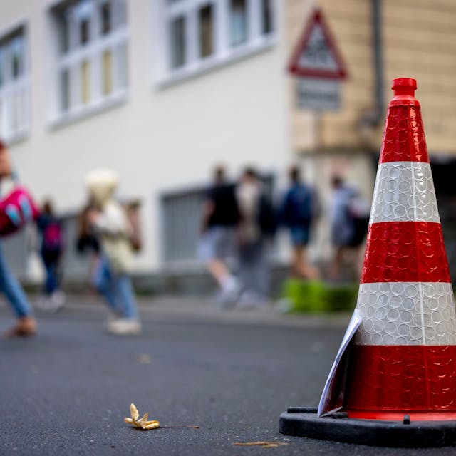 Pylonen stehen auf der Straße an der Bardelebenschule, ab 7.45 Uhr ist das Befahren der Straße für 45 Minuten untersagt, die Schüler kommen zu Fuß über den Gehweg. (zu dpa: «NRW-Kommunen können Straßen vor Schulen zeitweise sperren») Foto: Christoph Reichwein/dpa +++ dpa-Bildfunk +++