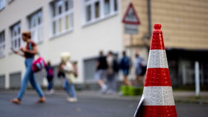Pylonen stehen auf der Straße an der Bardelebenschule, ab 7.45 Uhr ist das Befahren der Straße für 45 Minuten untersagt, die Schüler kommen zu Fuß über den Gehweg. (zu dpa: «NRW-Kommunen können Straßen vor Schulen zeitweise sperren») Foto: Christoph Reichwein/dpa +++ dpa-Bildfunk +++