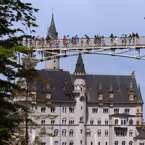 Touristen stehen auf der Marienbrücke vor dem Schloss Neuschwanstein.