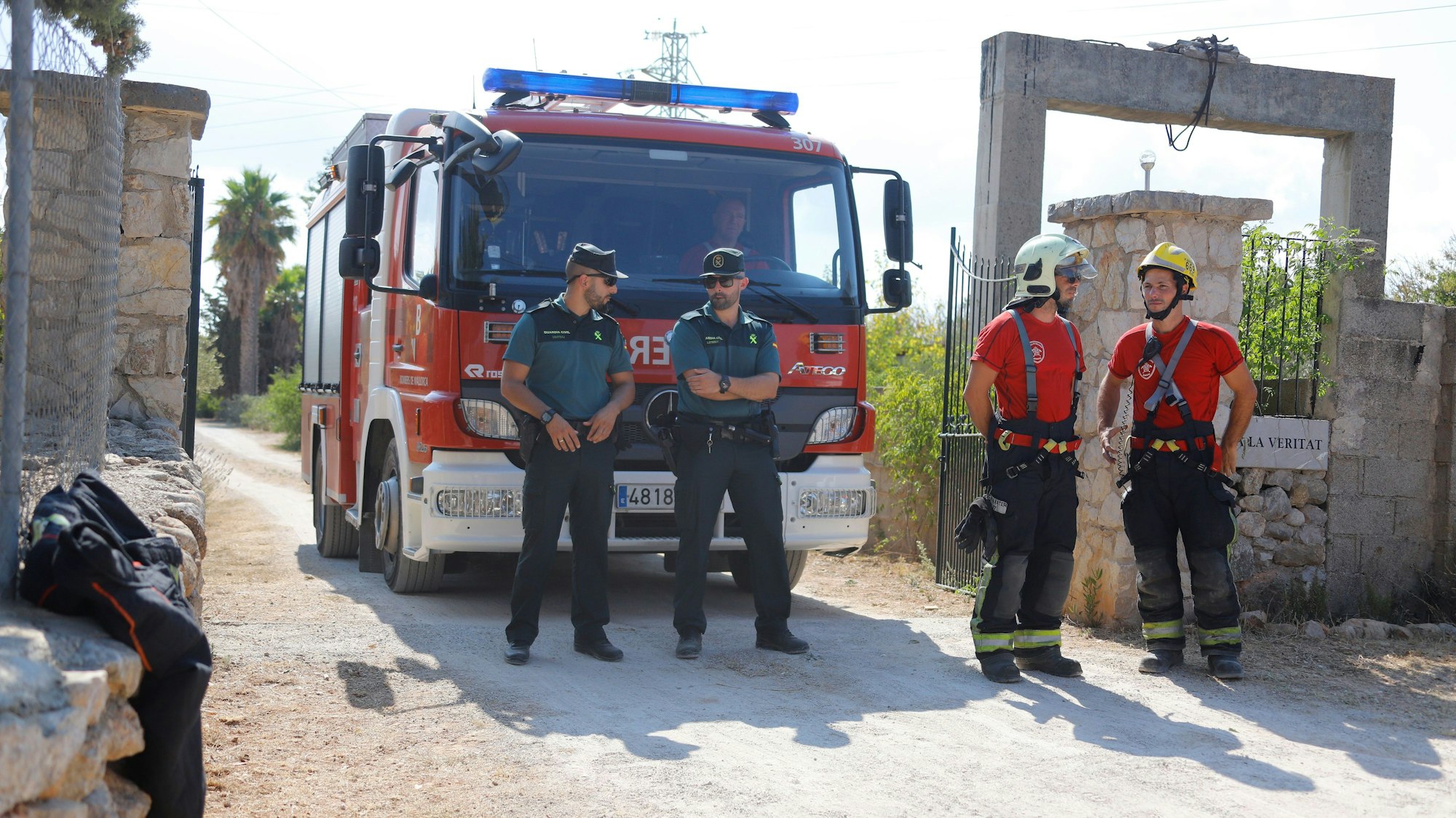 Mitglieder der Polizeieinheit „Guardia Civil“ (l) und der Feuerwehr stehen nach einer Kollision zwischen einem Flugzeug und einem Hubschrauber in der Nähe der Absturzstelle.