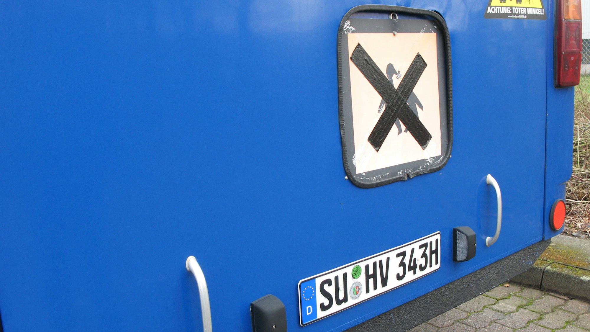 An Heck des Oldtimerbusses ist oberhalb des H-Kennzeichens ein altes Schulbusschild angebracht.