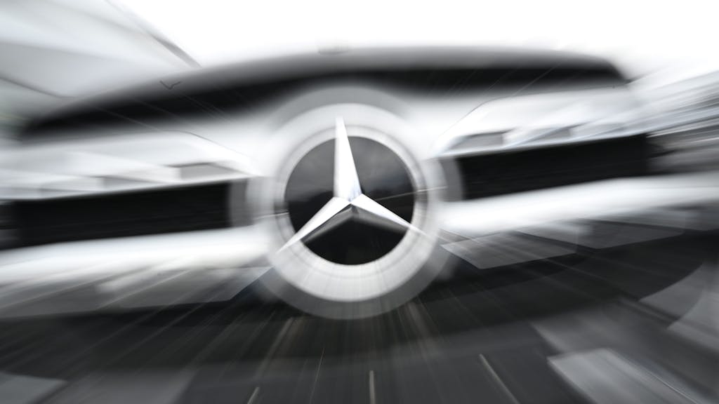 Das Logo der Automarke Mercedes-Benz ist an der Front eines Mercedes-Benz Fahrzeugs angebracht (Wischeffekt durch Langzeitbelichtung und Zoomen).