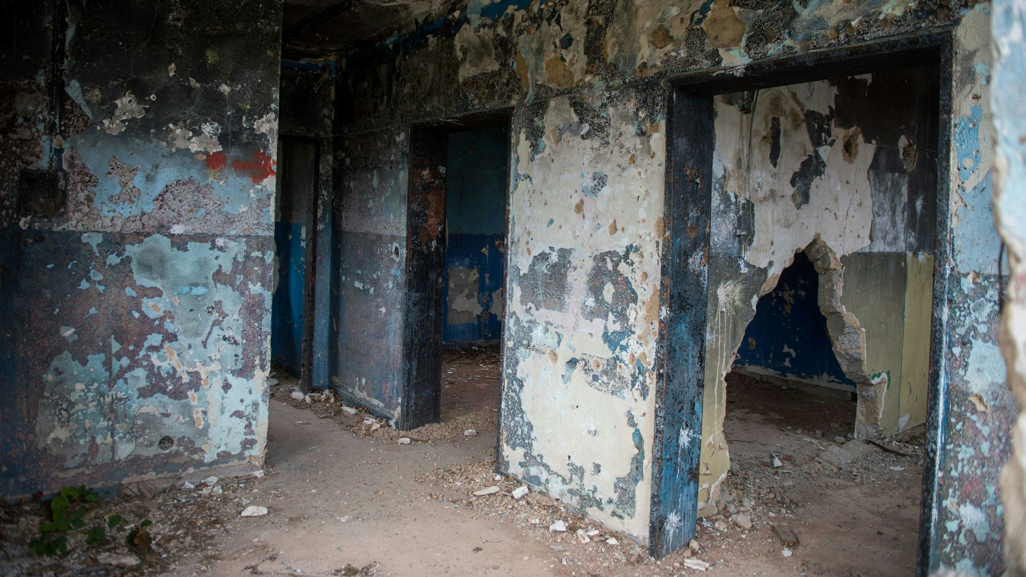 Das Bild zeigt das Innere eines ehemaligen militärisch genutzten Gebäudes, von dem nur noch die Mauern erhalten sind.