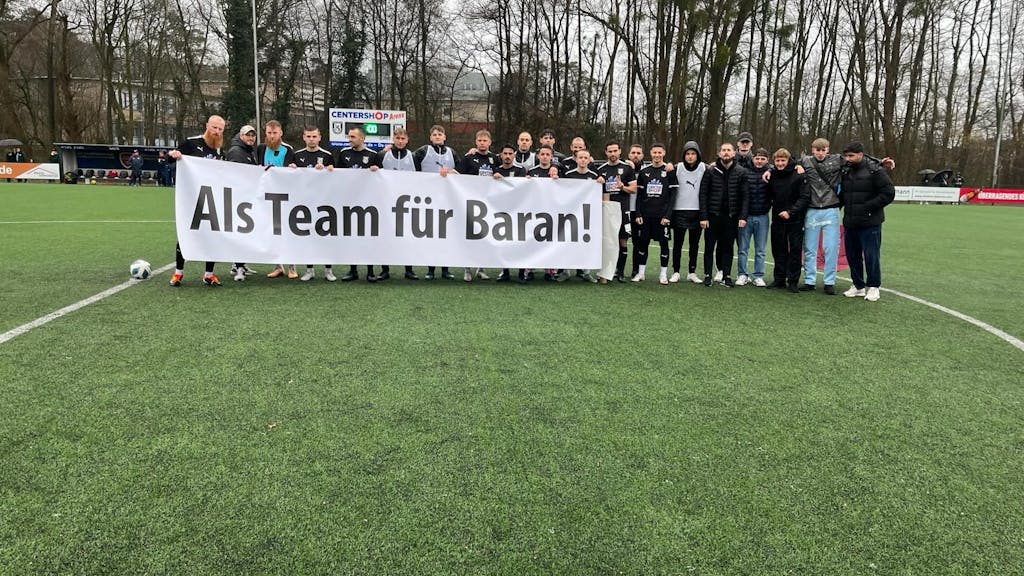 Mit dem Spruch „Als Team für Baran“ auf einem Banner zeigte sich die Mannschaft vom SSV Jan Wellem am Sonntag (18. Februar 2024) solidarisch mit ihrem entlassenen Trainer Baran Dagdelen.