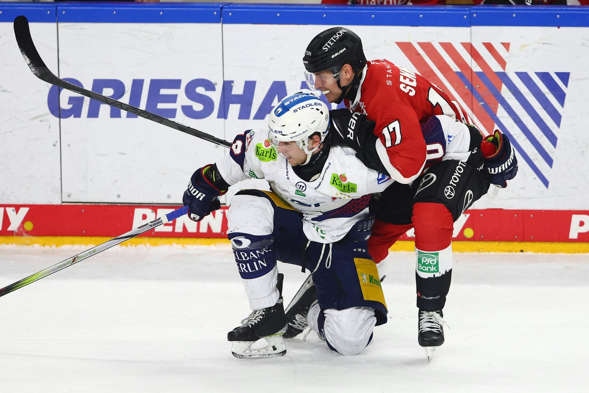 Zwei Eishockeyspieler befinden sich in einem Zweikampf.